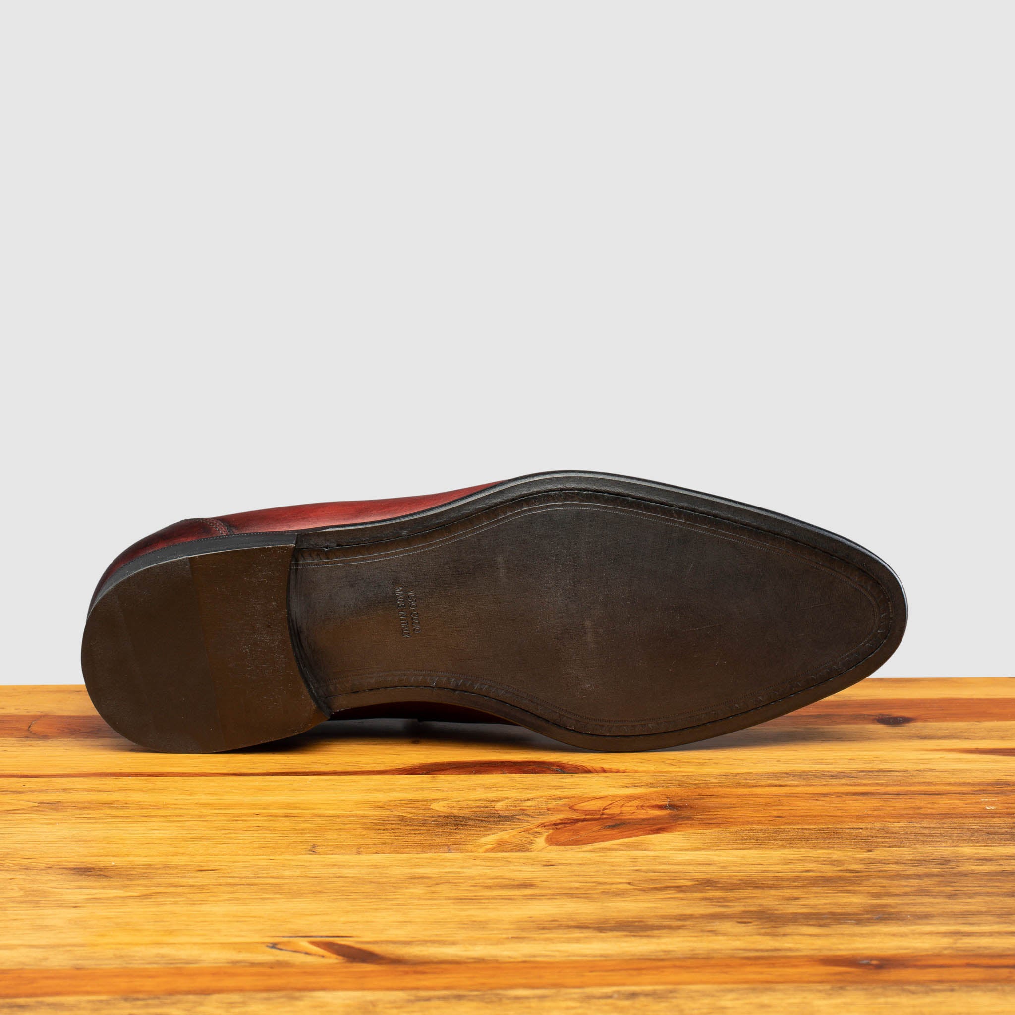 Outsole of Porpora leather loafer on a wooden surface with a light gray background