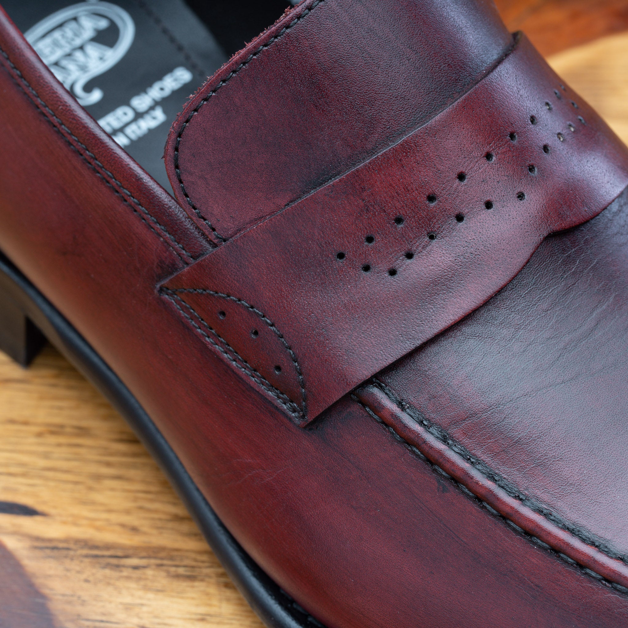 Porpora leather loafer on a wooden surface with a light gray background