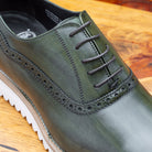 Close-up of Green leather shoe on a wooden surface