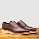 A Pair of Porpora Lace Ups leather shoe on a wooden surface with a gray background