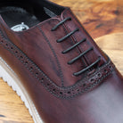 Close-up of Porpora Lace Ups leather shoe on a wooden surface