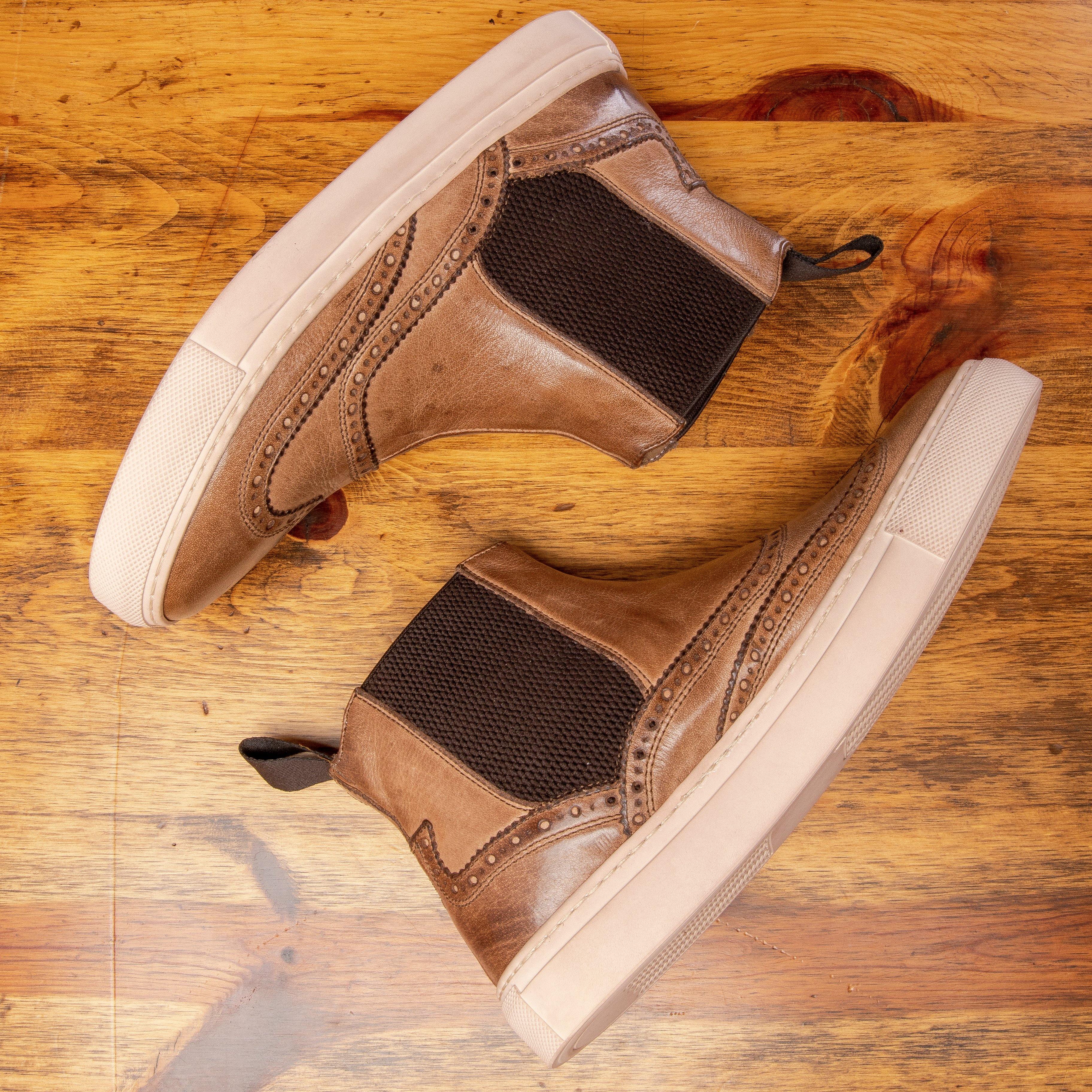 Pair of Brown leather shoe on a wooden surface