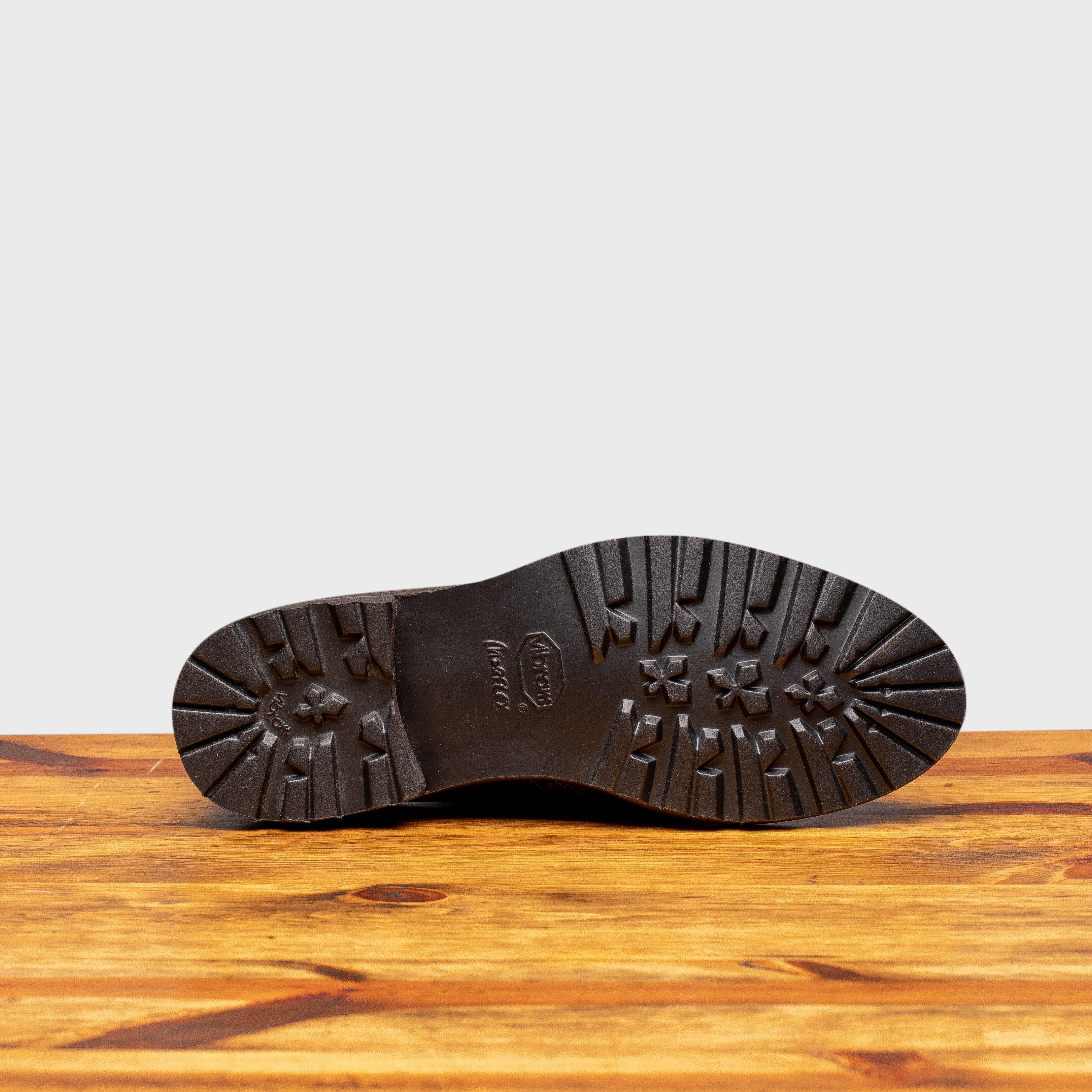 Outsole of Brown leather shoes on a wooden surface