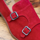 Close view of Red suede loafer with brown sole on a wooden surface