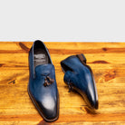 Pair of Blue leather loafer with a tassel on a wooden surface