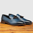 Pair of Blue leather loafer with a tassel on a wooden surface