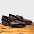 Pair of Porpora leather loafer with a tassel on a wooden surface