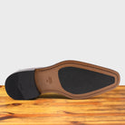 Outsole of Porpora leather loafer with a tassel on a wooden surface
