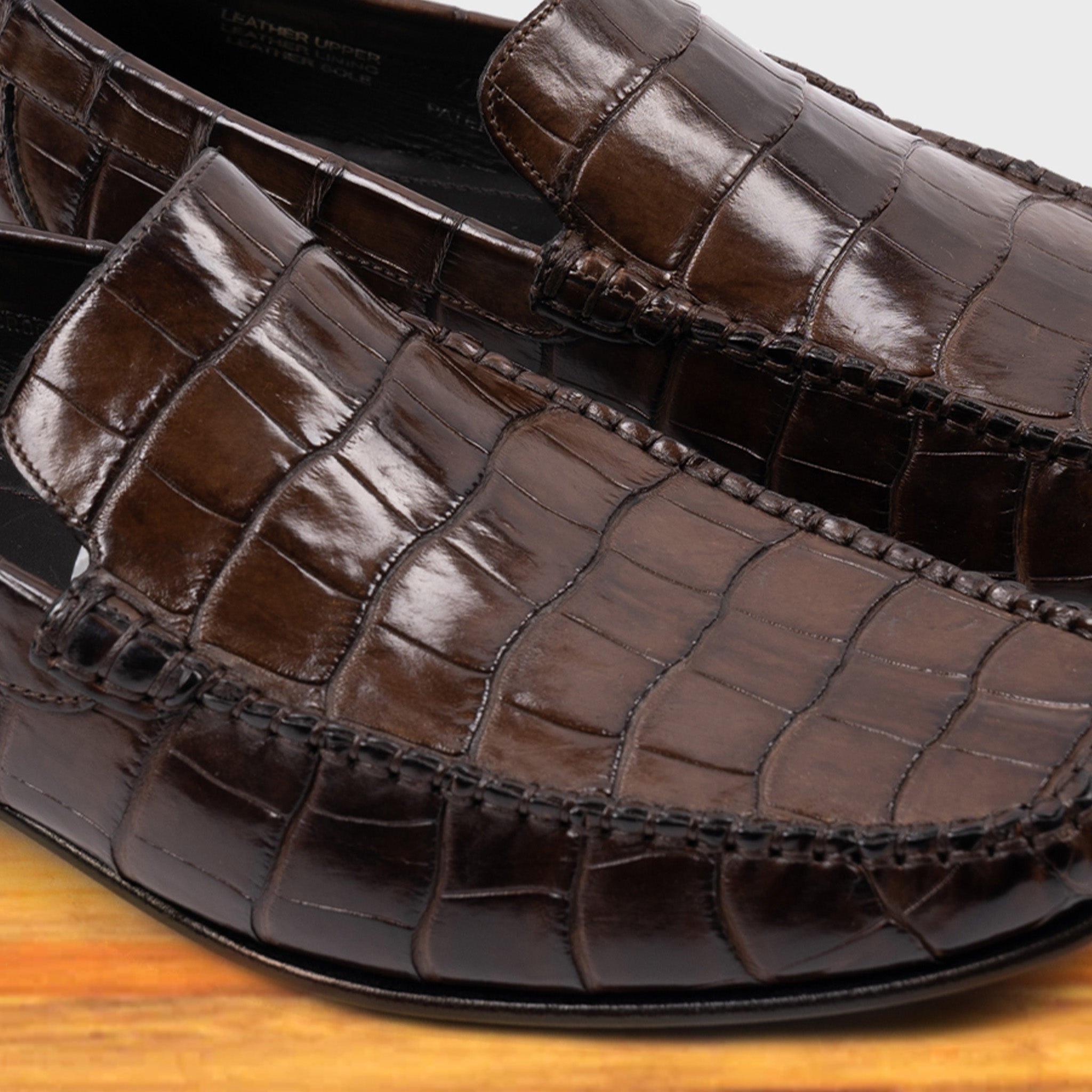 Moor crocodile-patterned loafer on a wooden surface