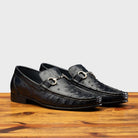 Pair of Blue leather loafer on a wooden surface with a light gray background