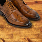 Pair of Caramel leather dress shoe on a wooden surface