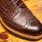 Close view of Brown leather shoes on a wooden surface