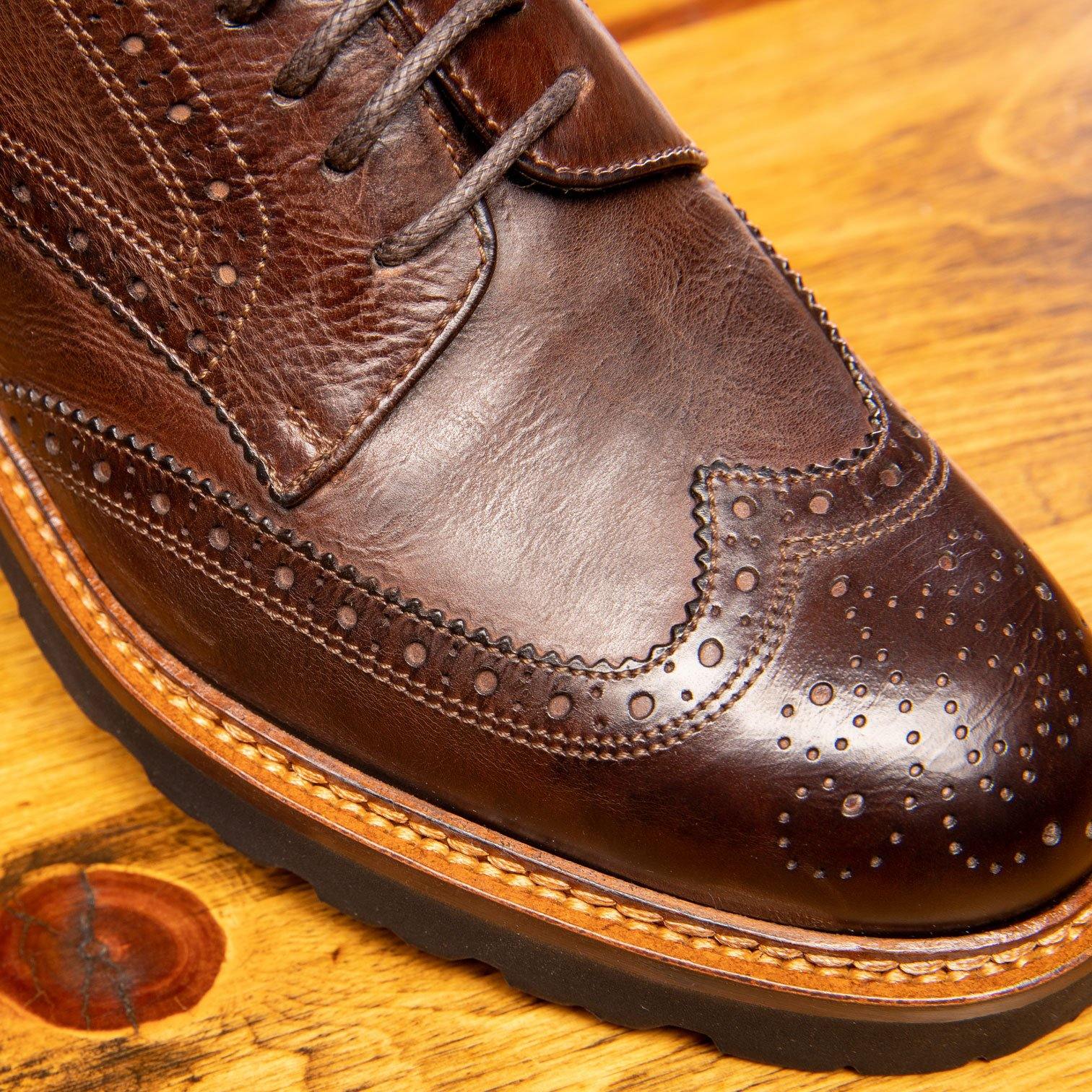 Close view of Brown leather shoes on a wooden surface