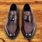 Pair of Porpora leather loafer with a tassel on a wooden surface